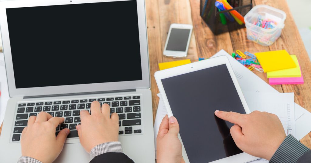 A person working across a laptop, tablet, and smartphone, illustrating cross-device customer journeys